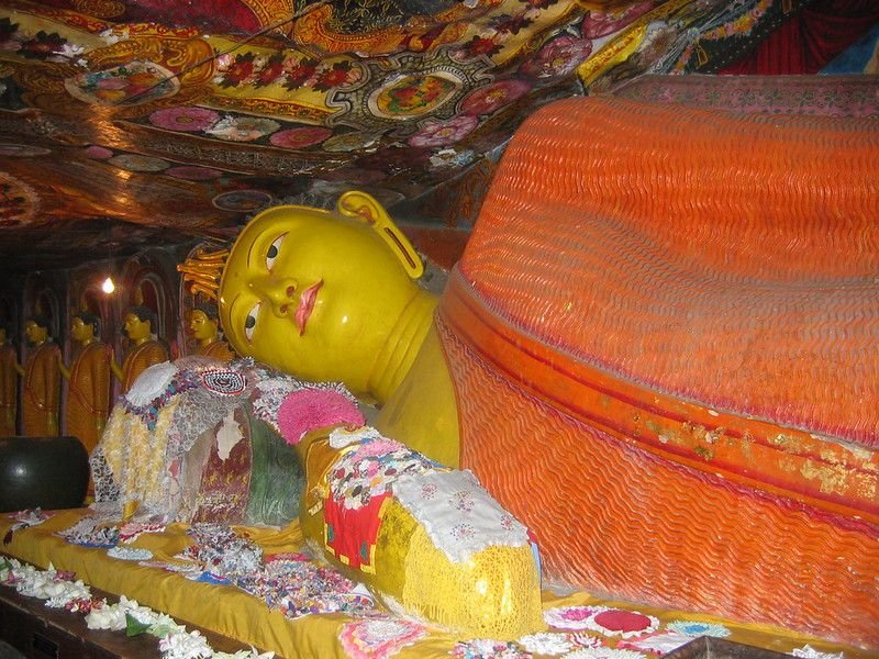 The reclining Buddha in the main cave, under painted rock. The murals are comparatively modern; the rock is not.